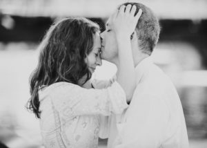 man kissing his wife on the forehead