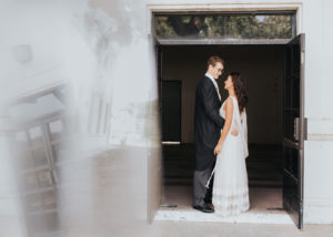 couple in wedding outfits in doorway