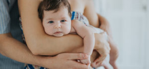 baby held in her parents arms