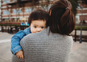 girl looking over moms shoulder