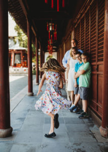 girl twirling with family watching