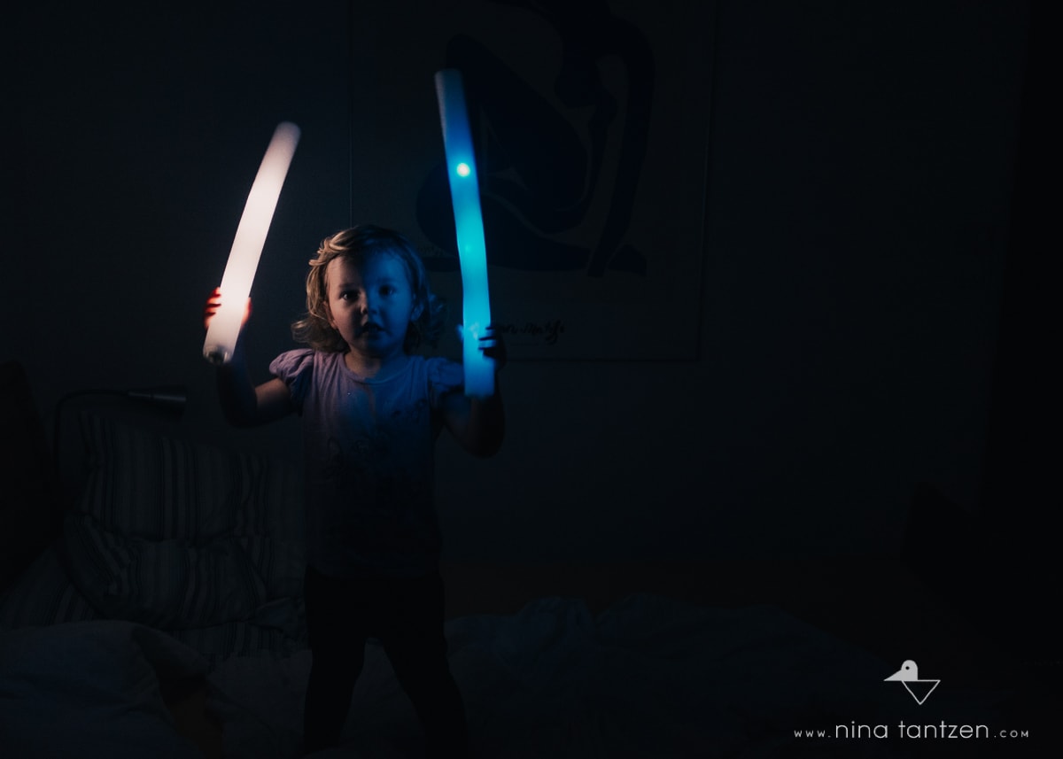 girl playing with light sabers