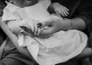 kleines Baby hält Hand der Mutter