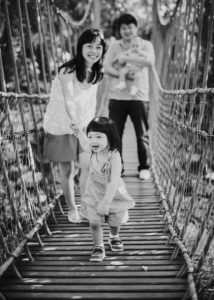 a family playing on a hanging bridge