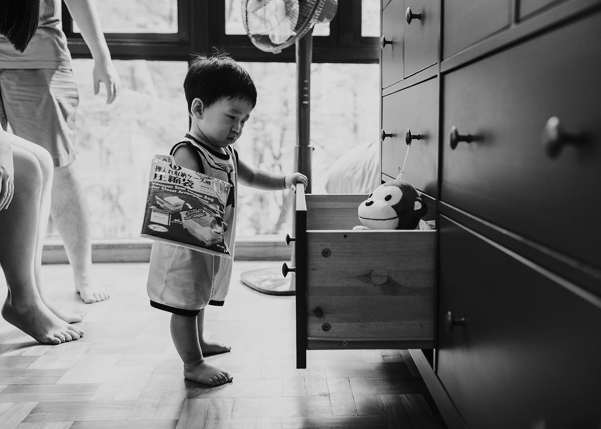 toddler standing next to open drawer
