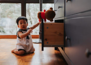 little boy sitting next o open drawer