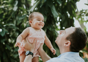 dad lifting up his baby in a park