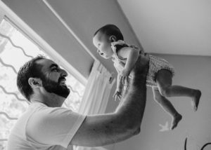 dad lifting up his baby in a room