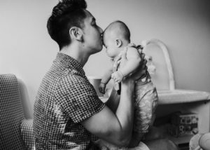 dad kissing his baby on the forehead