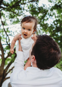 dad lifting up his baby daughter