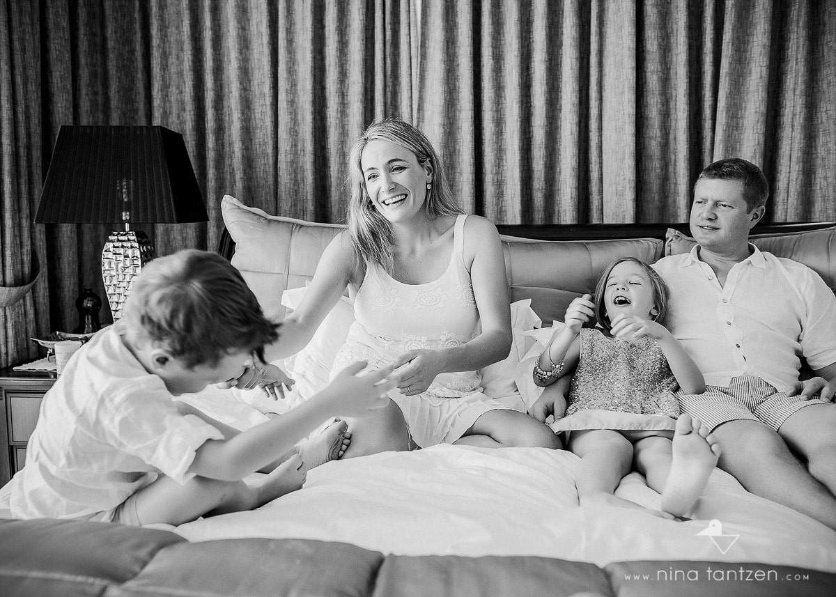 family laughing together on the bed
