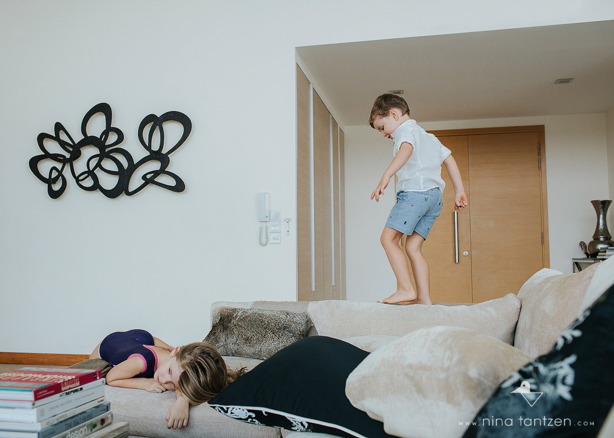 photo of children climbing on the sofa