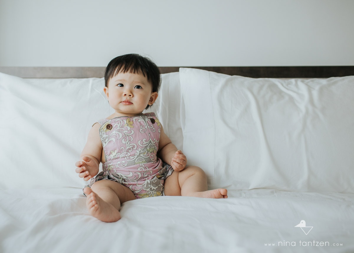 toddler sitting on bed