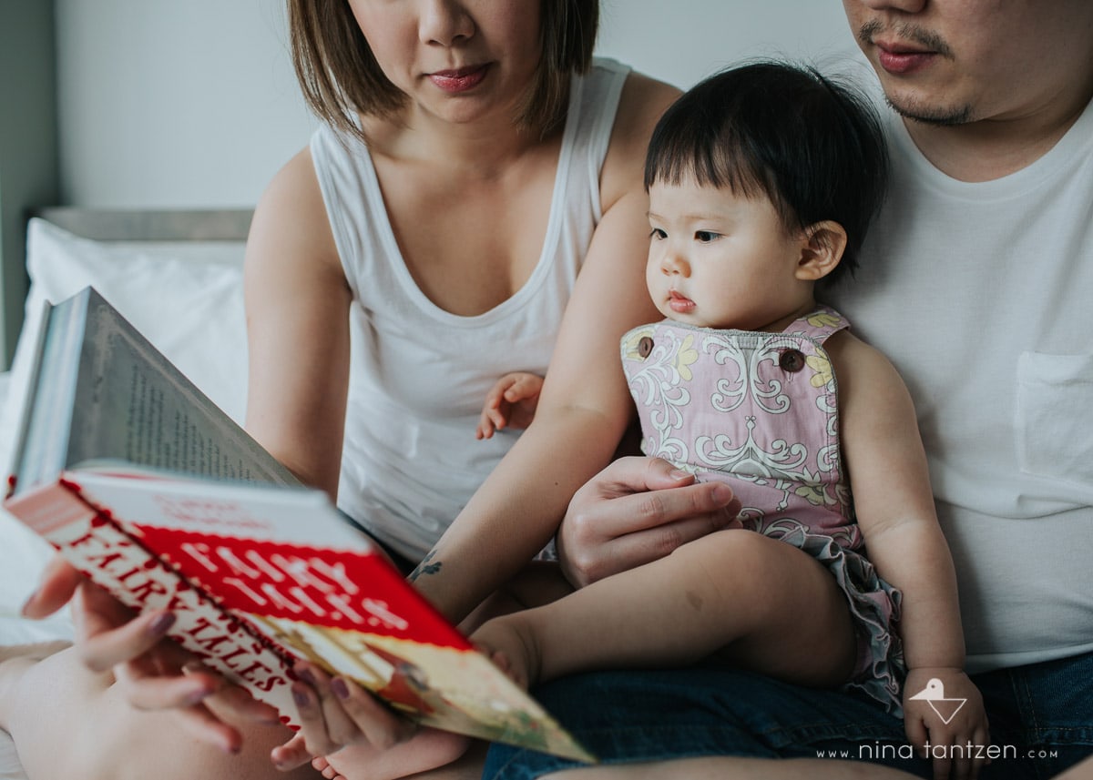 parents and toddler reading book