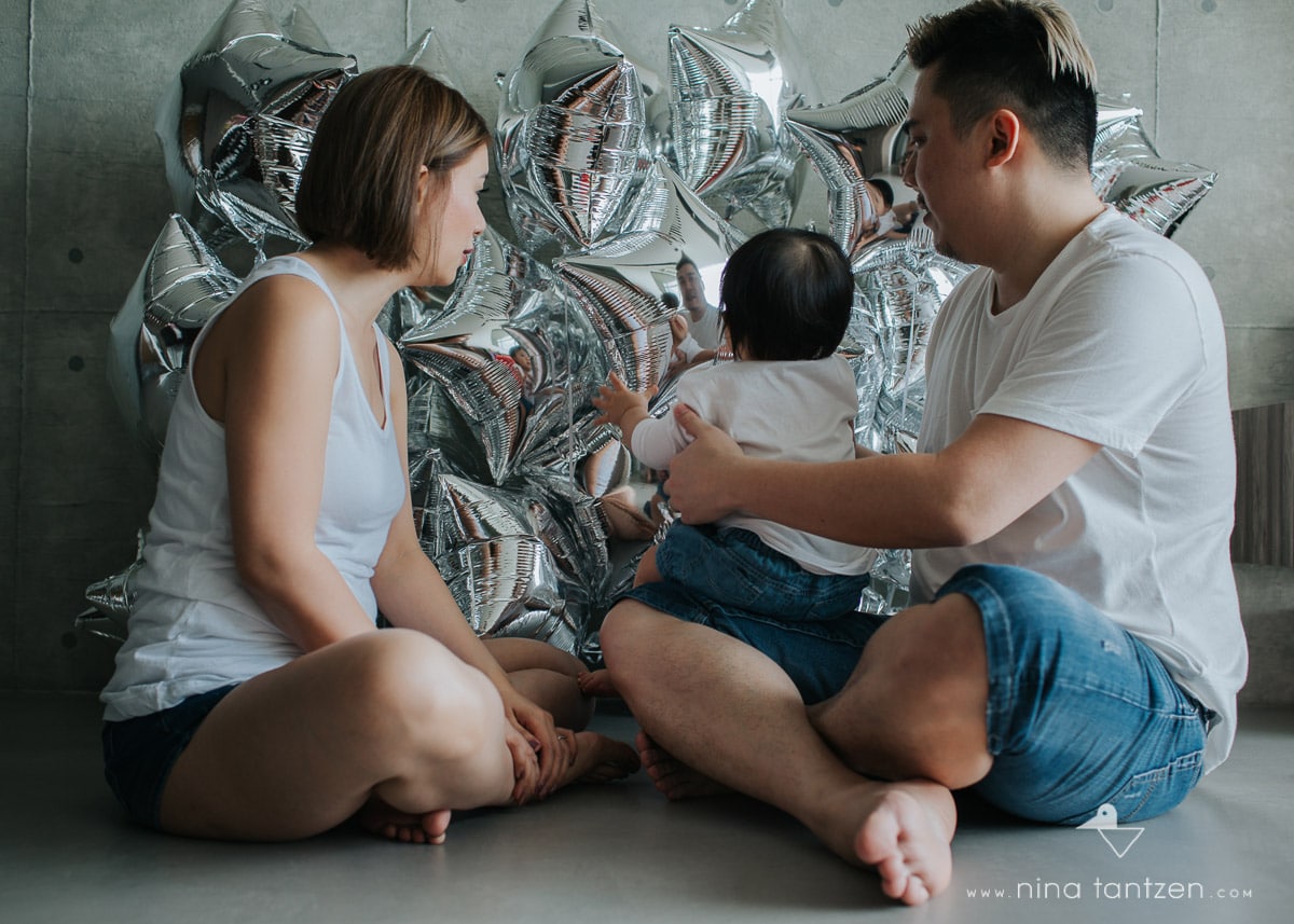 family with toddler and silver balloons