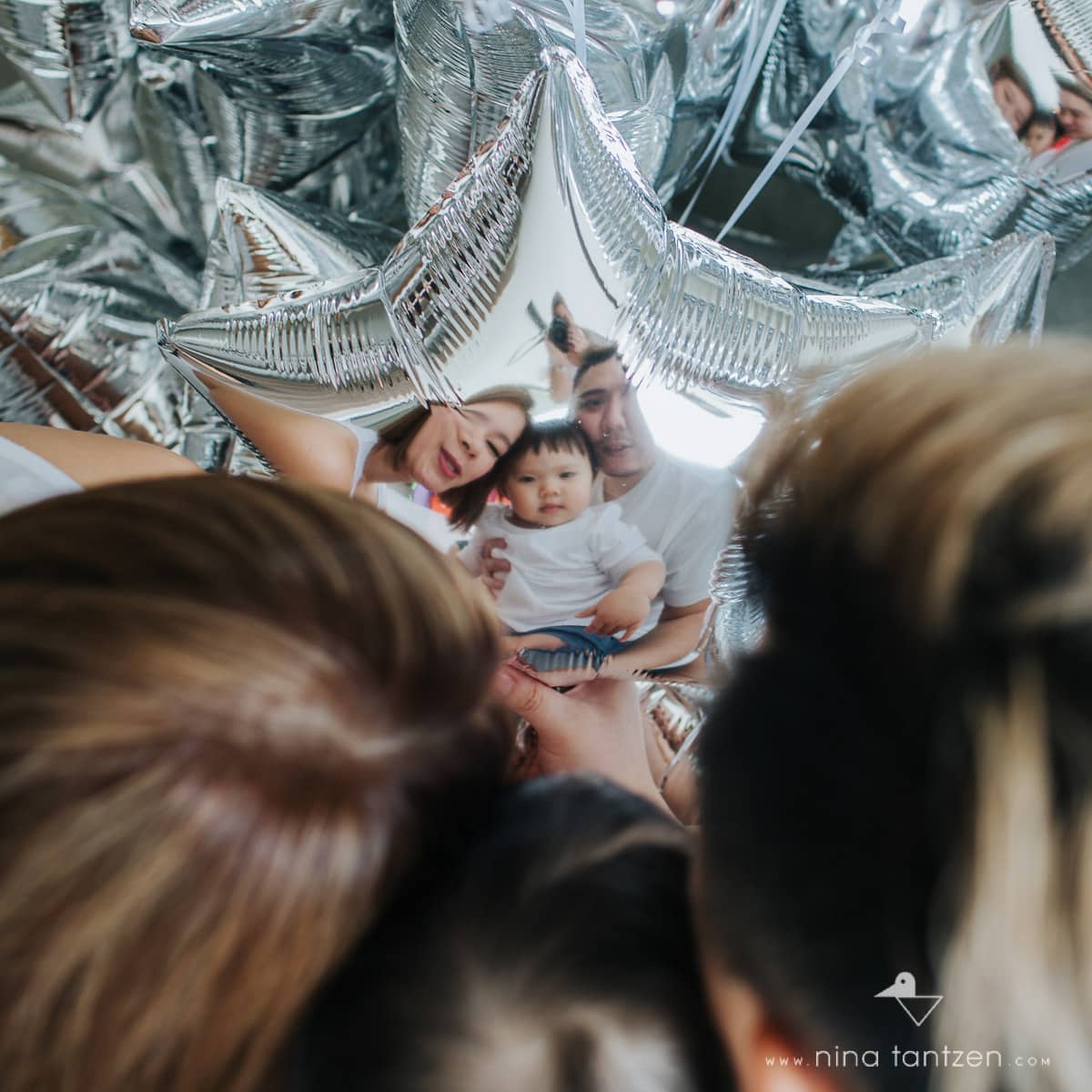family reflection in silver balloons