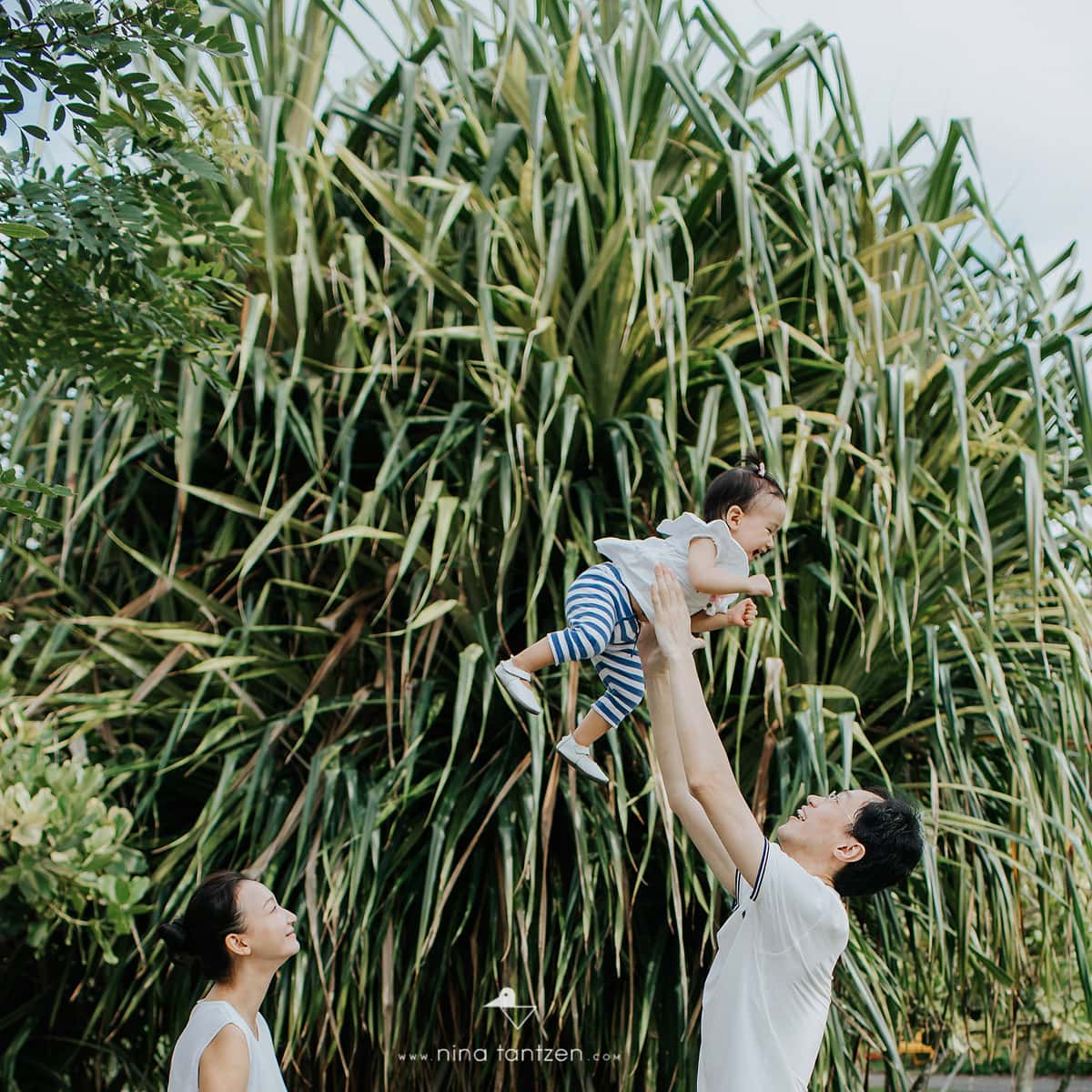 happy family portrait with baby girl outdoors