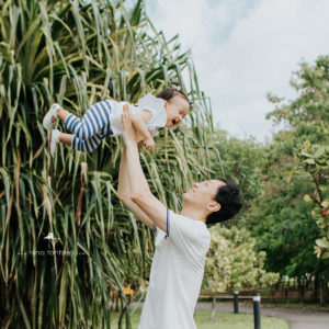 dad lifting giggling baby girl up high