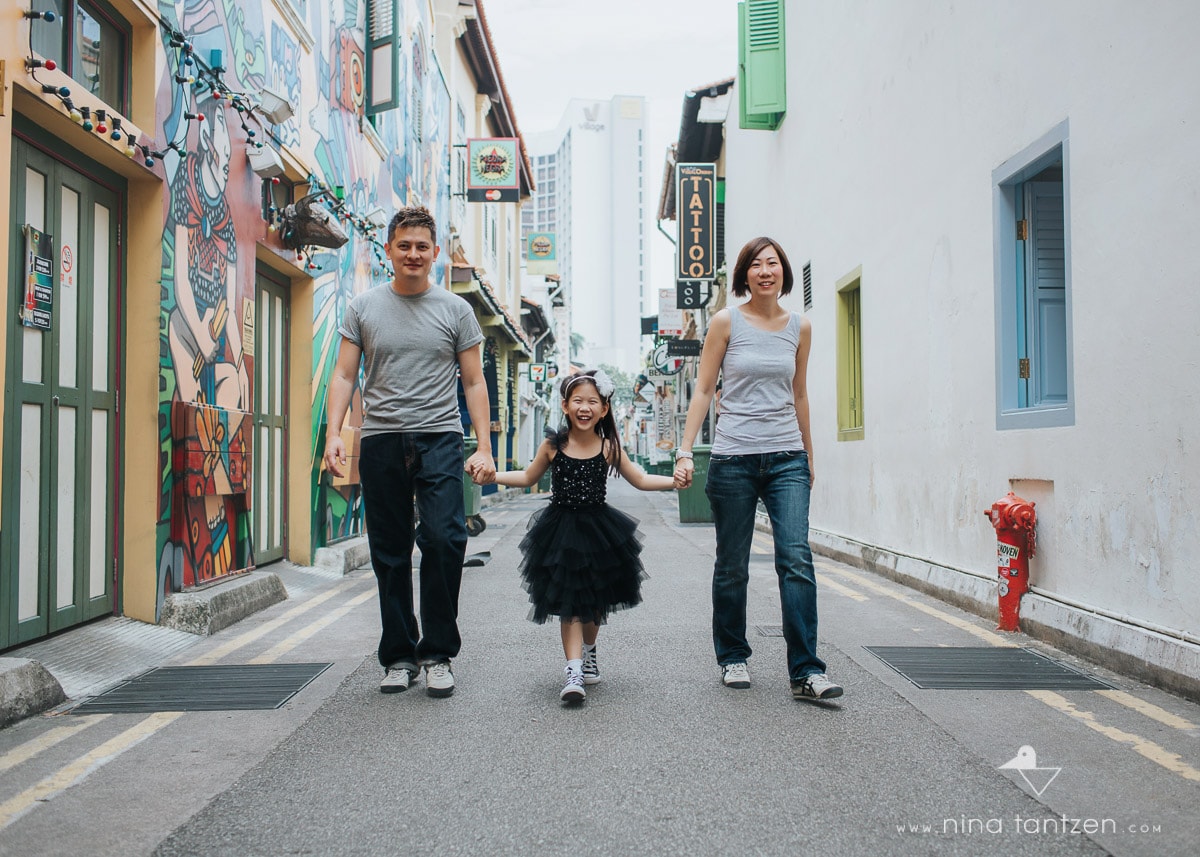 family of three walking on haji lane