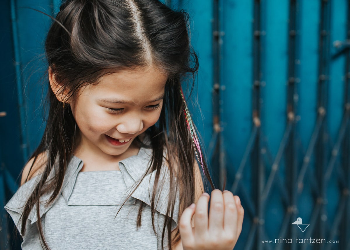 photo of little girl playing with her hair