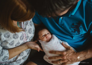 newborn baby girl in her parents' arms