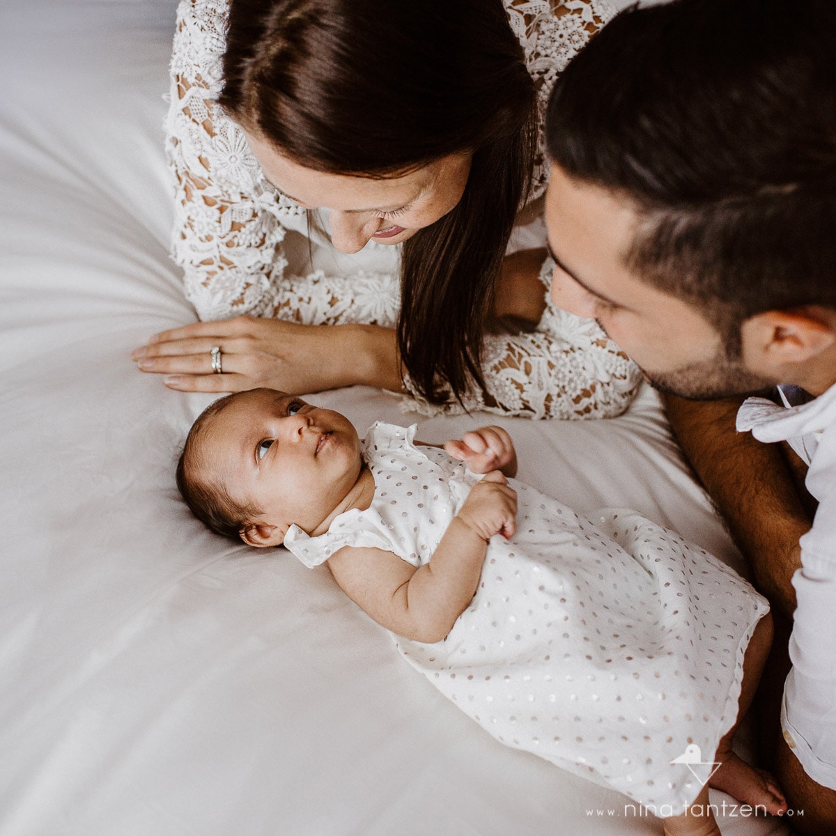 baby looking at her parents