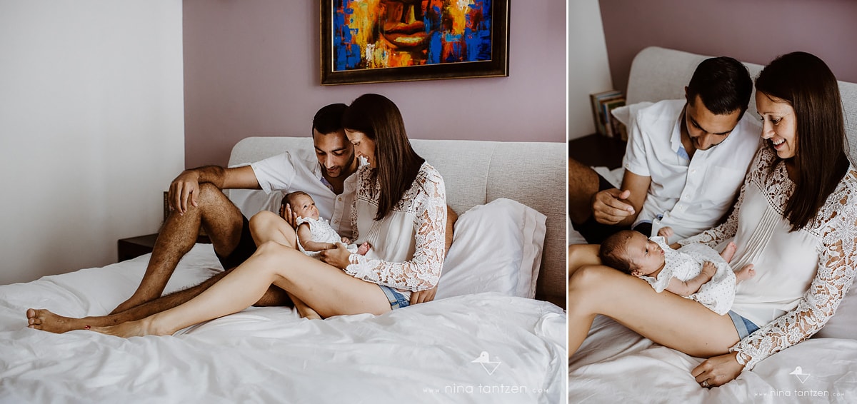 parents playing with baby on bed