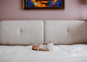 tiny newborn baby on big bed