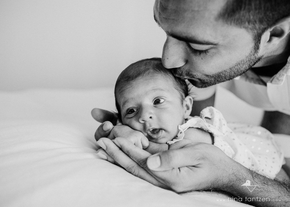 dad kissing newborn baby