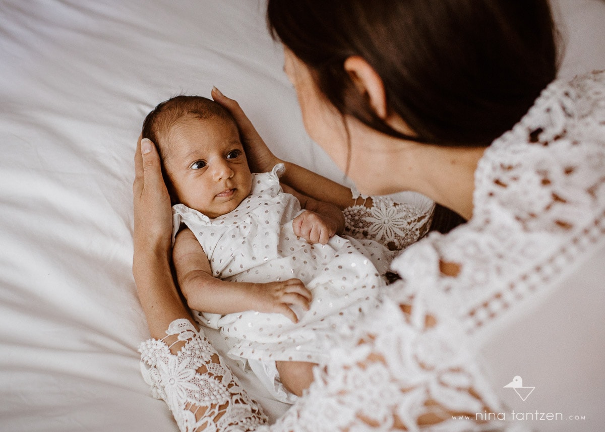 mom and baby playing on bed