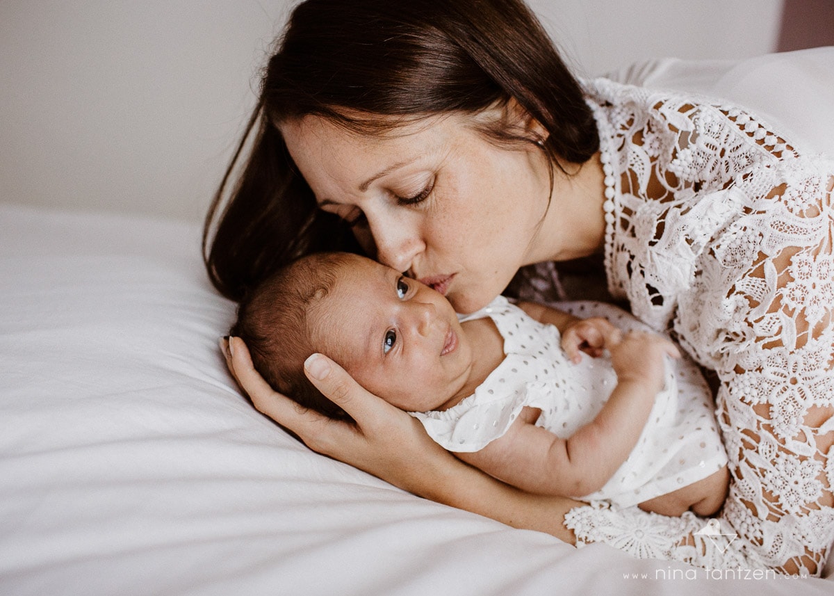 mom kisses her newborn baby