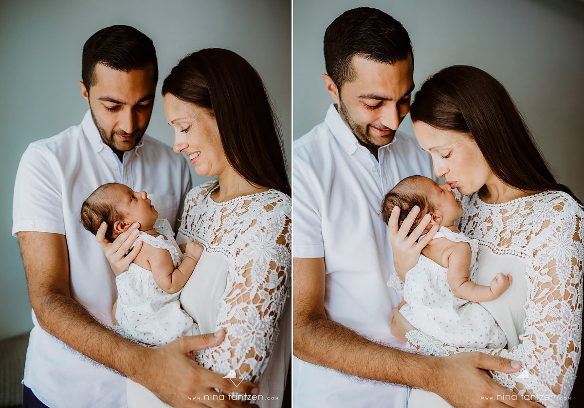 parents standing with newborn baby