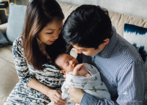 parents cradling their newborn baby girl