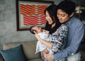 dad hugging mom with newborn baby
