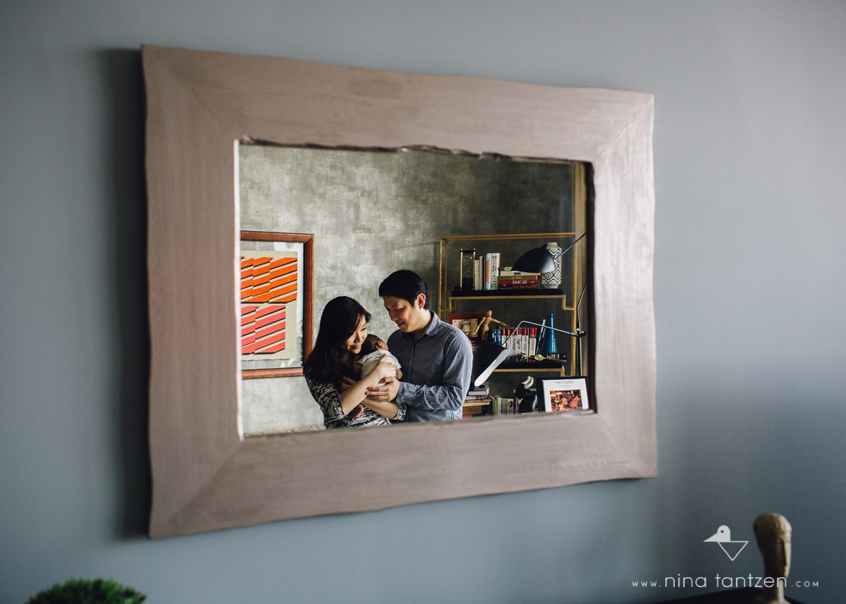 parents with baby reflected in mirror