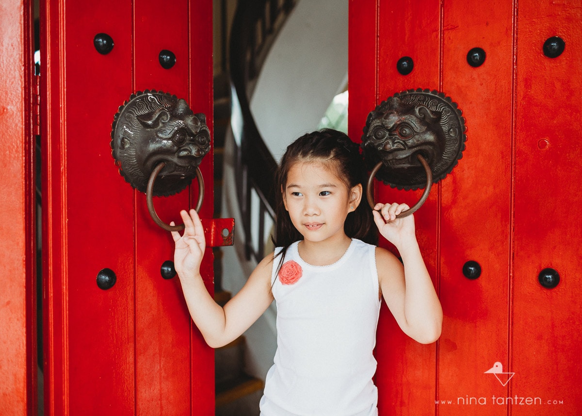 girl in front of red doors