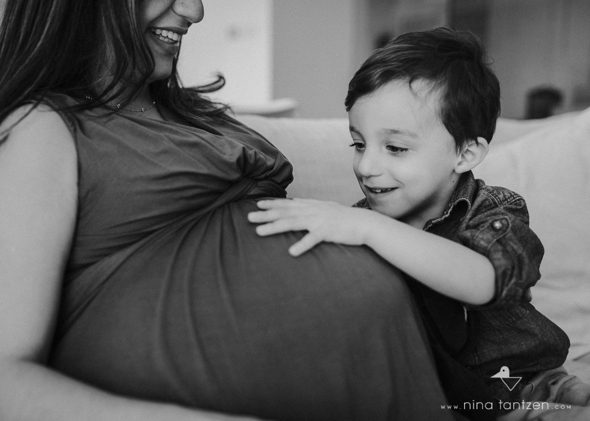 little boy feeling his mum's pregnant belly