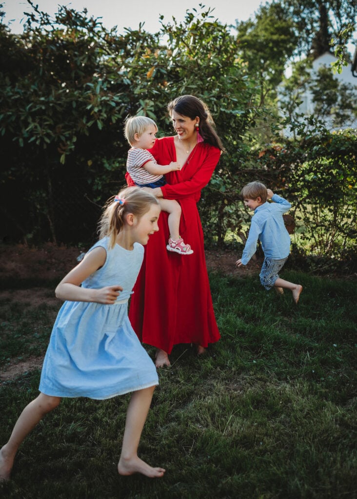 Kinder laufen um die Mama herum