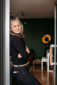 personal branding foto von Cafe-eigentümerin die in der tür lehnt