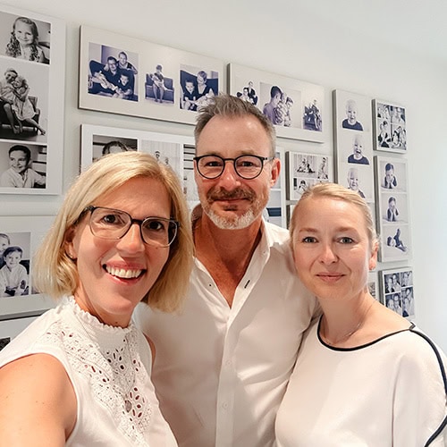 Zurich family photographer with clients in front of gallery wall